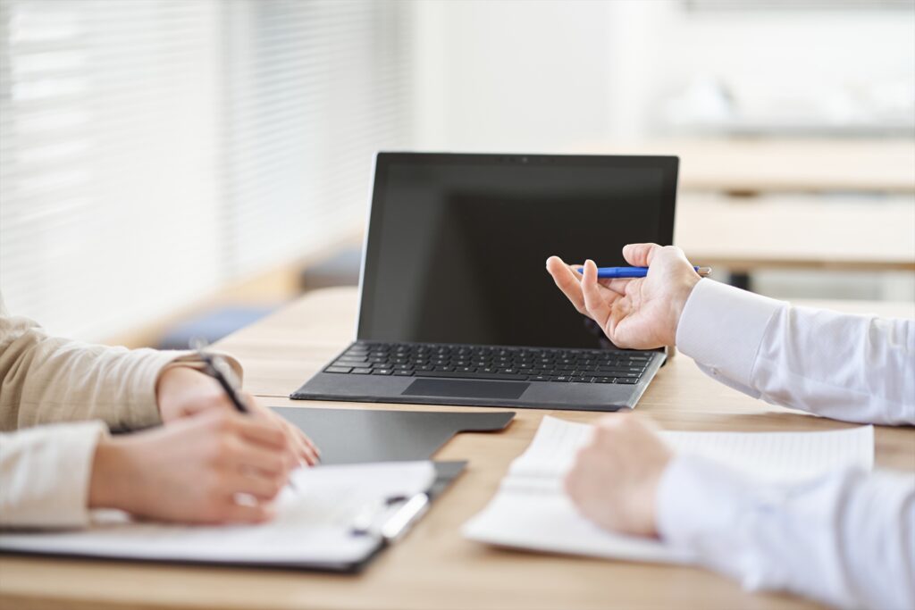 ノートパソコンで打ち合わせをするアジア人ビジネスパーソン