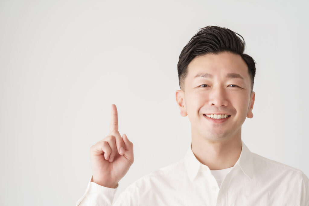 人差し指を立てるポーズをする男性