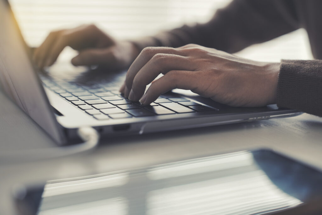 ラップトップと女性の手元