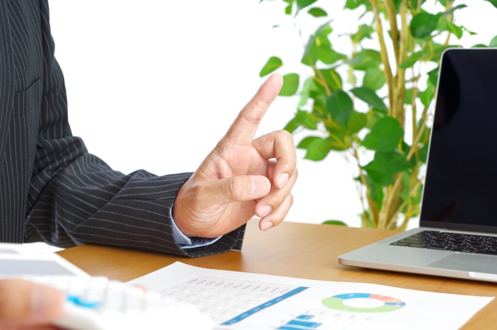 資料がのったテーブルで説明をする男性