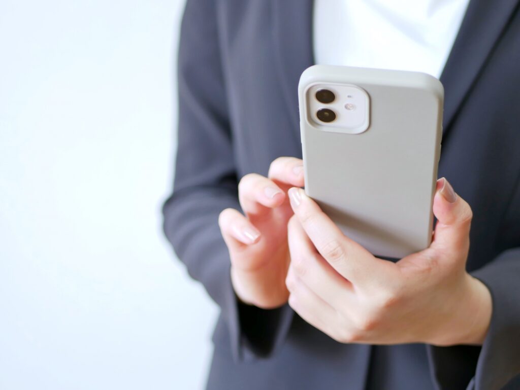 スマートフォンを操作するスーツの女性