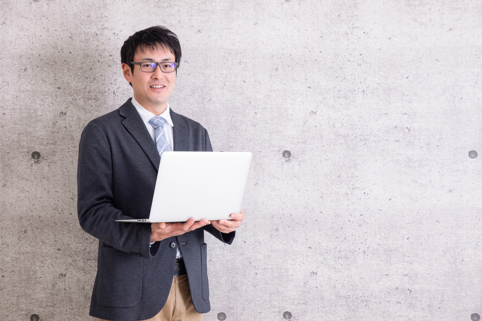 パソコンを持って立っている男性