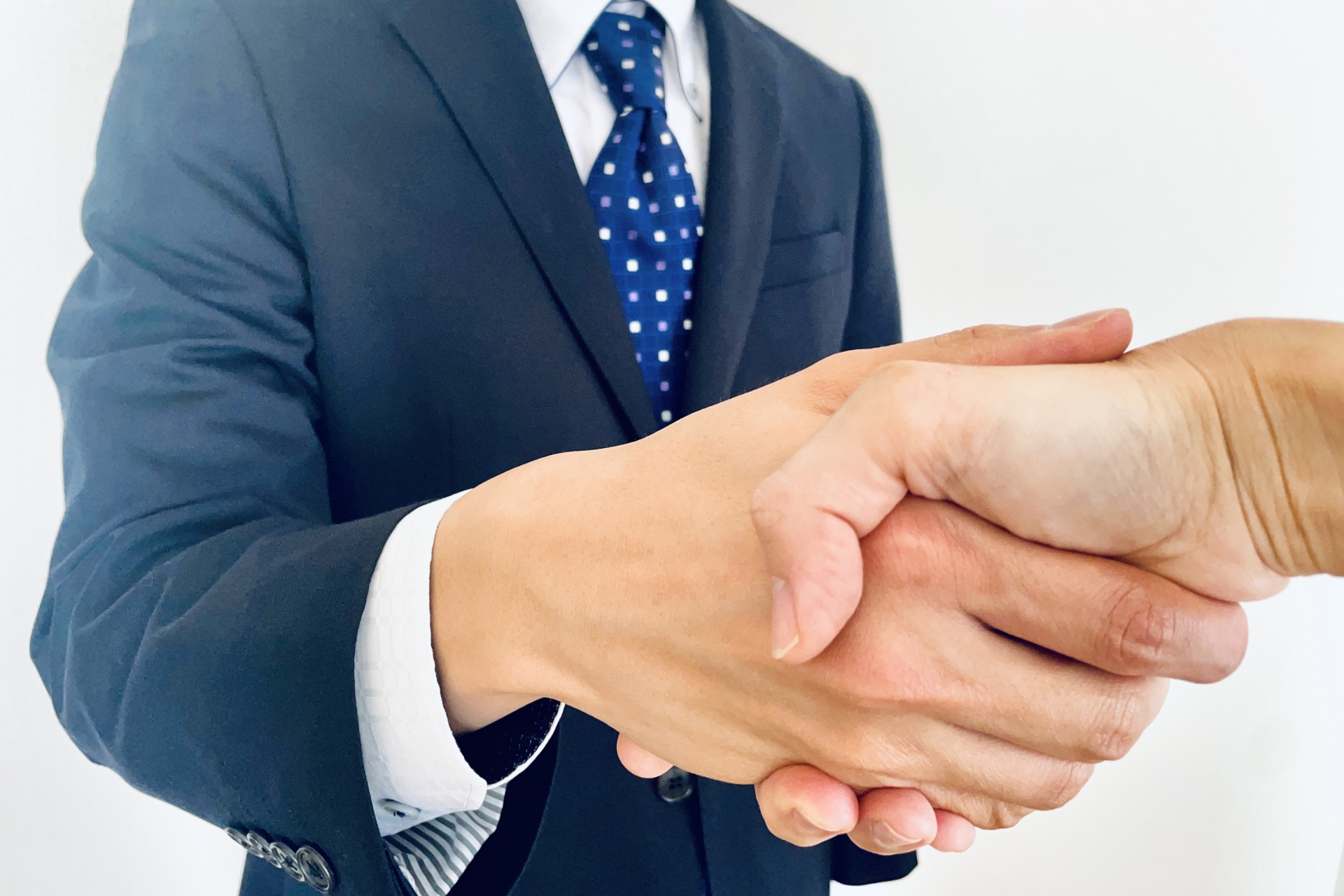 握手をしているスーツの男性
