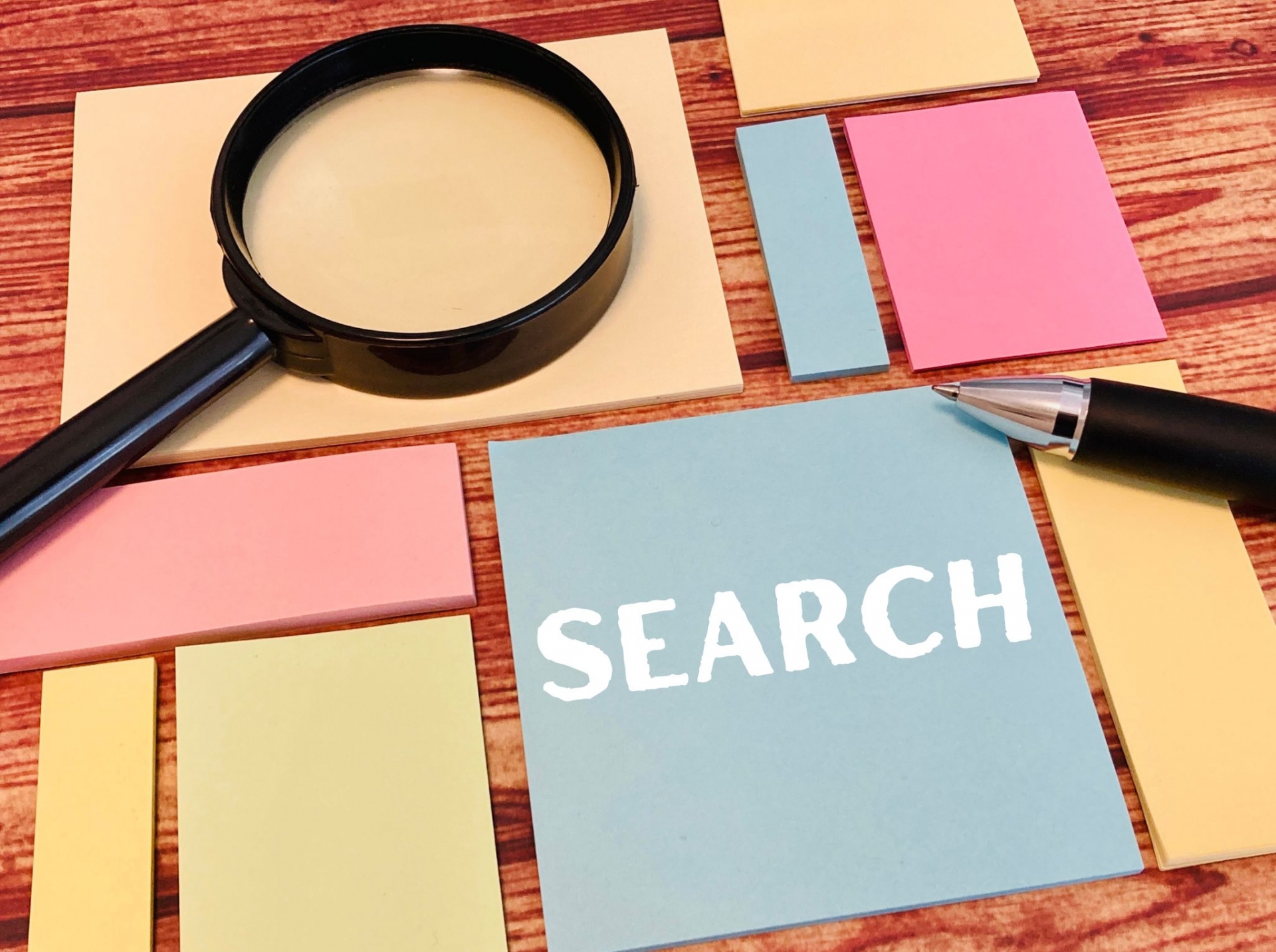 虫眼鏡とペンとたくさんの付箋